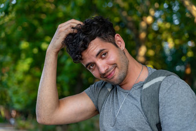 Portrait of young man standing against trees