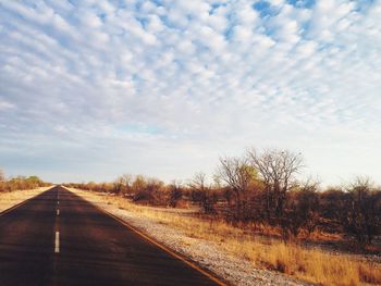 Empty road against cloudy sky