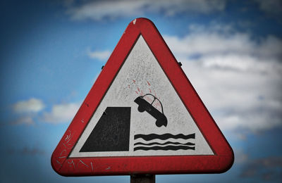 Close-up of road sign against sky