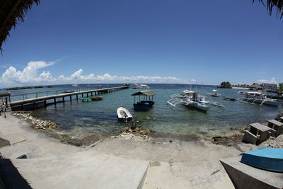Boats moored in sea against sky