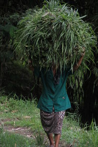 Rear view of woman walking on field