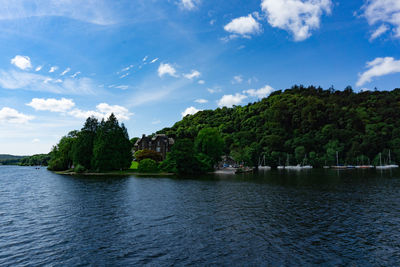 Scenic view of river by trees against sky