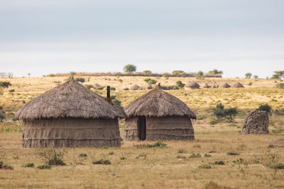 Scenic view of huts on field against sky