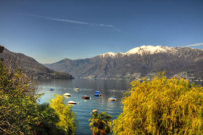 Scenic view of lake and mountains against blue sky