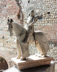 Statue against brick wall