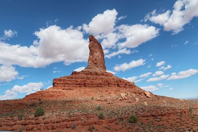 Landscape of desert greenery and a massive vertical rock spire