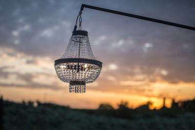 Precious glass chandelier exposed outside at sunset.