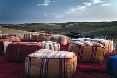 Lounge chairs on land against sky