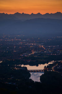 High angle view of illuminated cityscape against sky during sunset