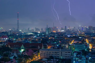 Illuminated cityscape against sky at night