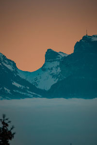 Scenic view of snowcapped mountains against sky during sunset