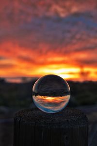 Close-up of crystal ball against sky during sunset