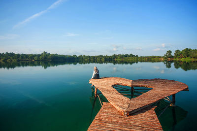 Rear view of man on lake against sky