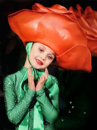 Smiling girl wearing costume standing against black background