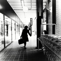 Rear view of woman walking in corridor