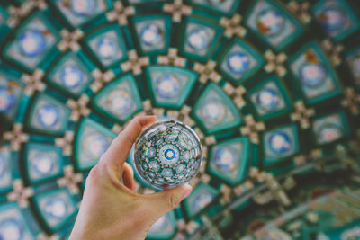 Close-up of human hand holding crystal ball with reflection