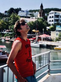 Man standing by railing in city