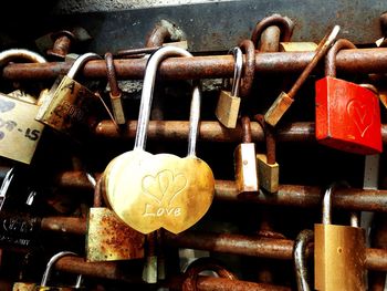 Close-up of padlocks hanging on rusty metal