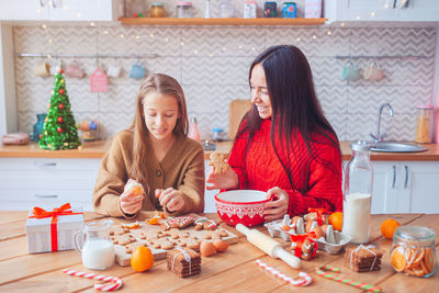 Smiling mother and daughter preparing food during christmas