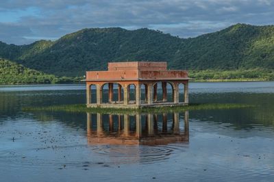 Built structure by lake against sky