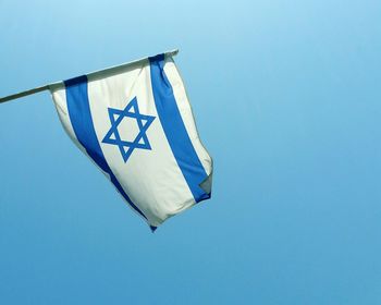 Low angle view of israeli flag against clear blue sky