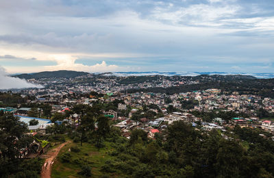 Downtown city view with dramatic cloudy sky at evening from mountain top