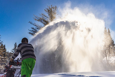 Man skiing on snow against sky