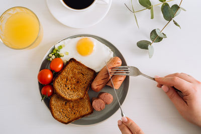 English breakfast with black coffee and orange juice, grilled sausage and whole wheat toast