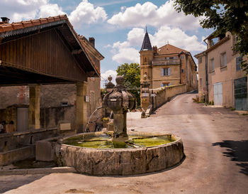 Fountain in old building against sky in city