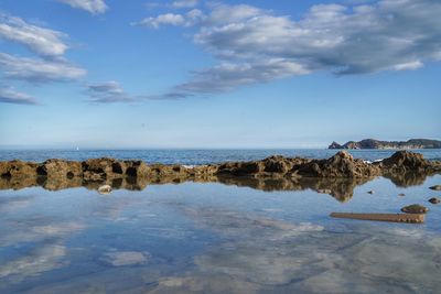 Rocks on beach against sky