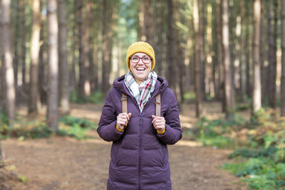 Portrait of smiling man standing in forest