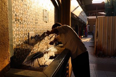 Man drinking water at fountain