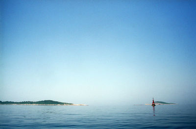 Boats in sea against clear sky