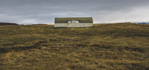 Built structure on field against sky