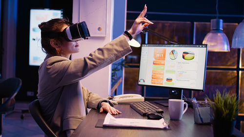 Midsection of businessman using laptop while standing in office