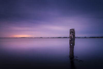 Scenic view of lake against sky at sunset