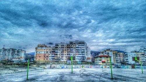 Buildings in city against cloudy sky