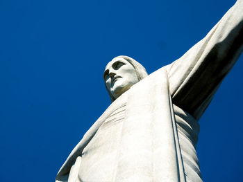 Low angle view of statue against blue sky