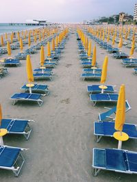 Deck chairs on beach against clear sky