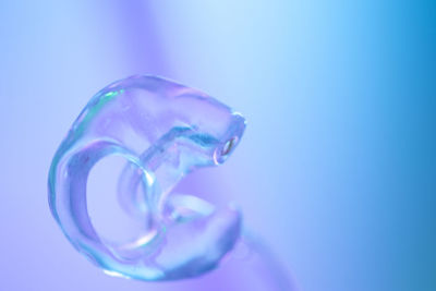 Close-up of glass of water against blue background
