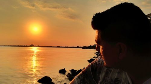 Side view of silhouette man at beach during sunset