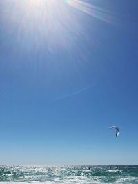 Scenic view of sea against blue sky on sunny day