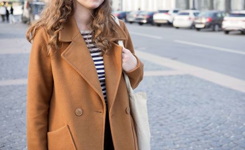 Midsection of woman standing in city