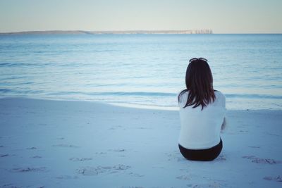 Rear view of lonely woman looking at sea