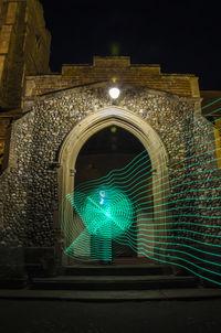 Low angle view of illuminated tunnel at night