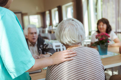 Female nurse taking care of senior people in nursing home