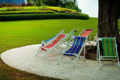 Empty chairs and table on field