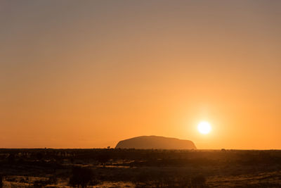 Scenic view of field against orange sky