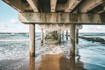 Interior of pier over sea against sky