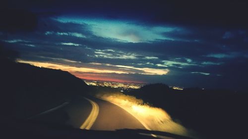 Road against cloudy sky at sunset